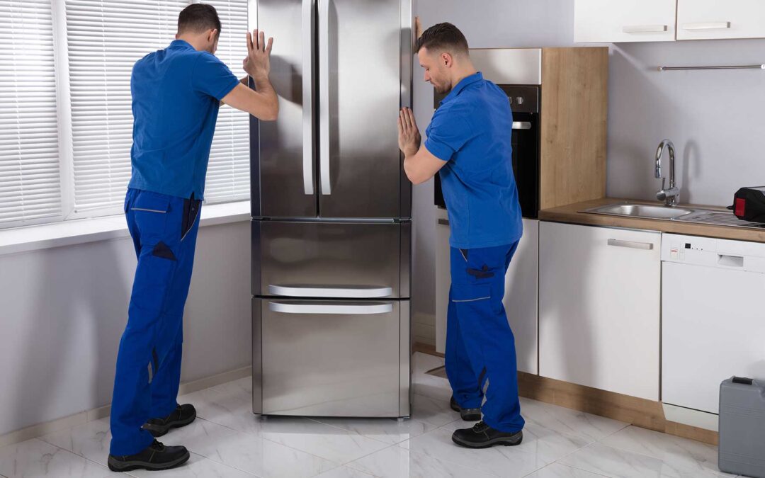 Stock photo of two movers installing a refrigerator