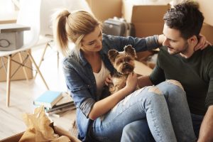 Couple with their dog unpacking in their new home