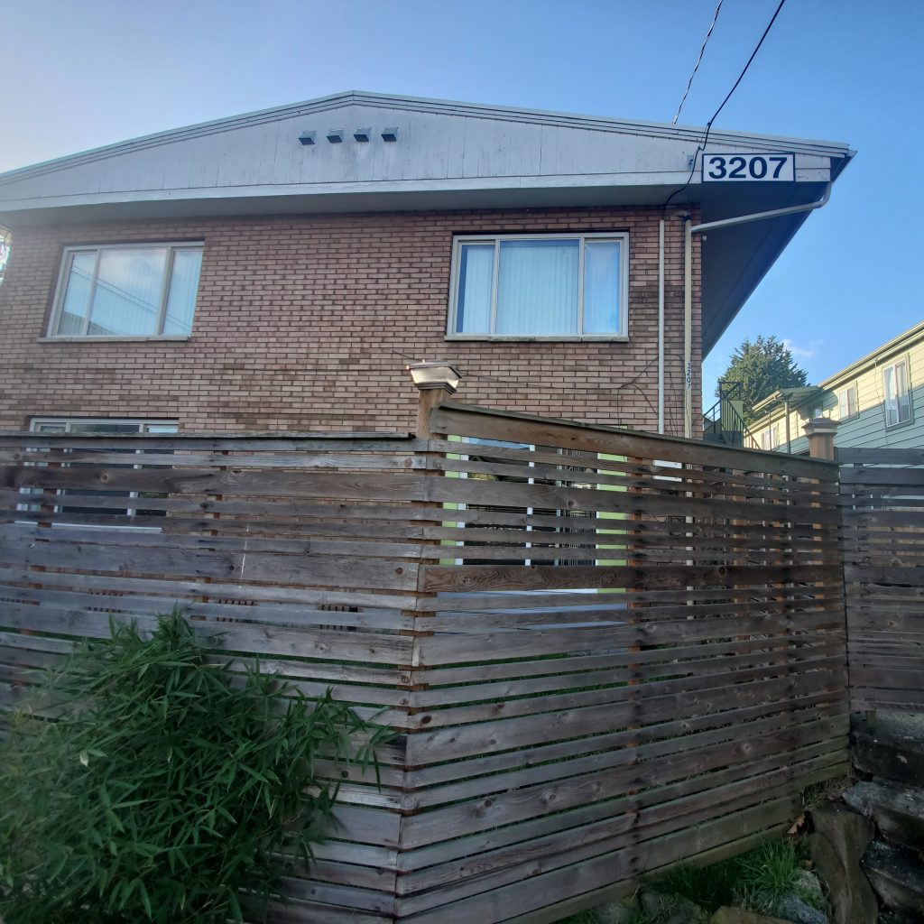The Magnolia 6 Apartments property exterior - fence and brick building